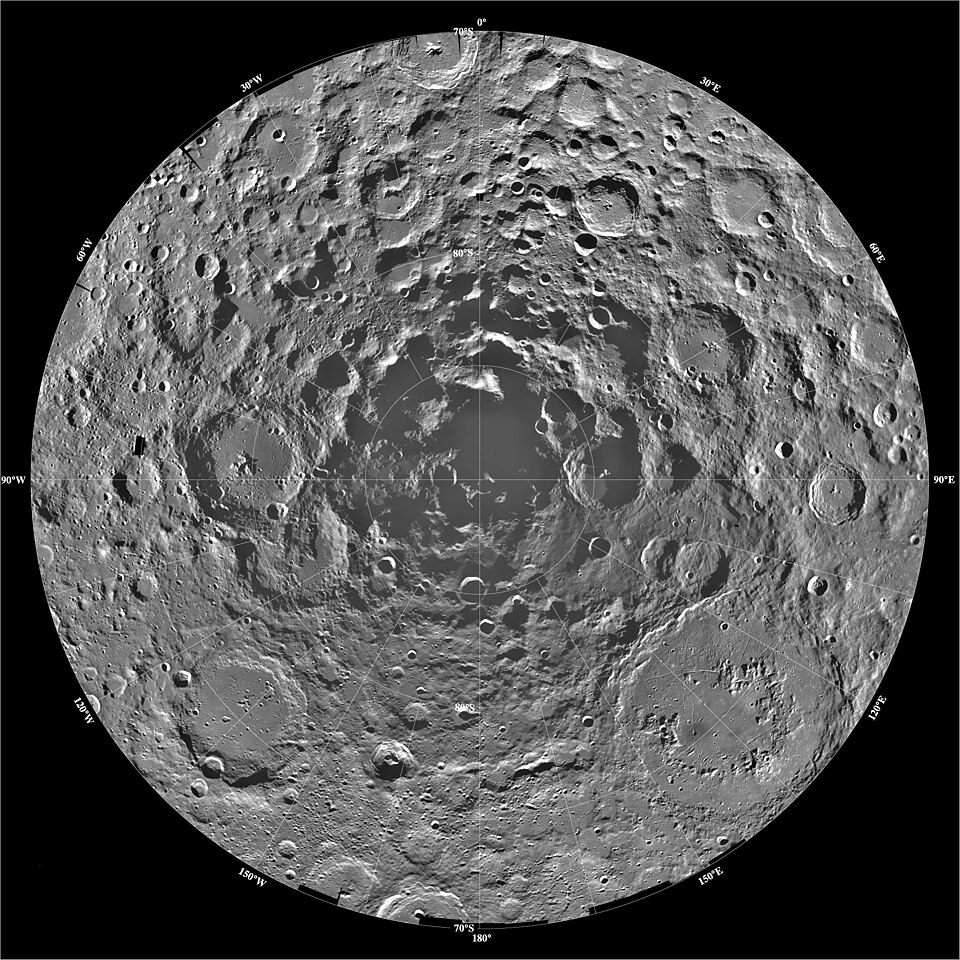A NASA polar-projection mosaic of the Moon's south polar region with a latitude-longitude graticule, showing densely cratered highlands and the deep black permanently shadowed crater floors near the pole