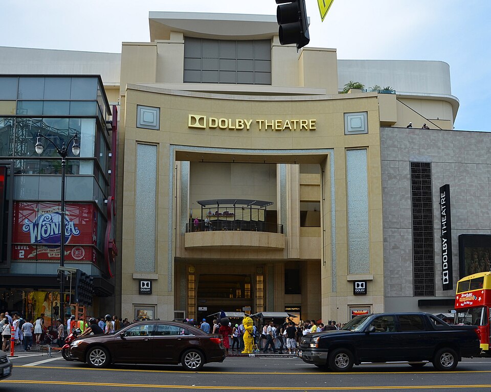 The Hollywood Boulevard entrance of the Dolby Theatre in Los Angeles, its curved stone facade carrying the gold DOLBY THEATRE lettering above the arched doorway