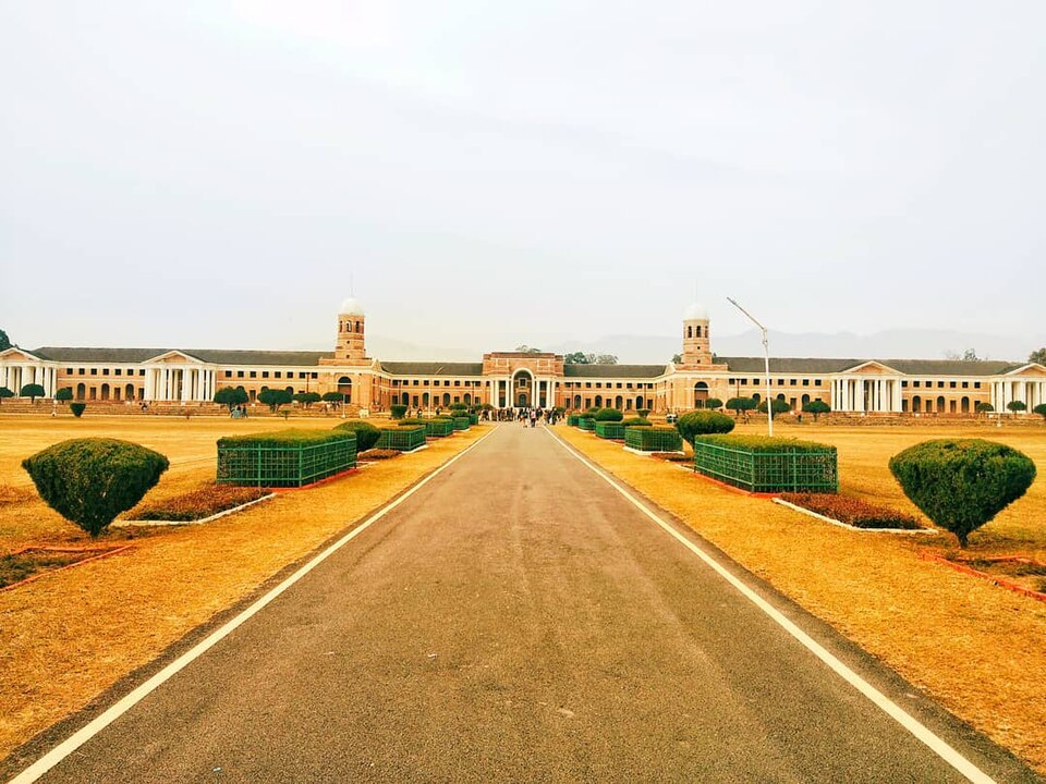 The long colonial brick-and-stone main building of the Forest Research Institute, Dehradun, seen down its central avenue across clipped lawns