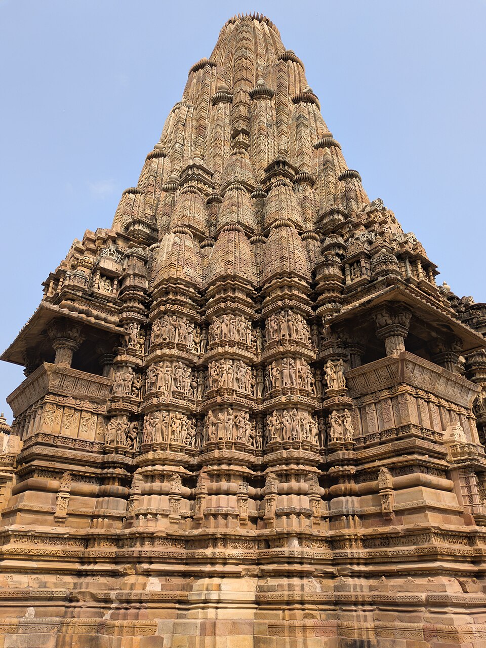 The soaring shikhara of the Kandariya Mahadeva temple at Khajuraho, built up from clustered miniature spires above bands of carved stone figures