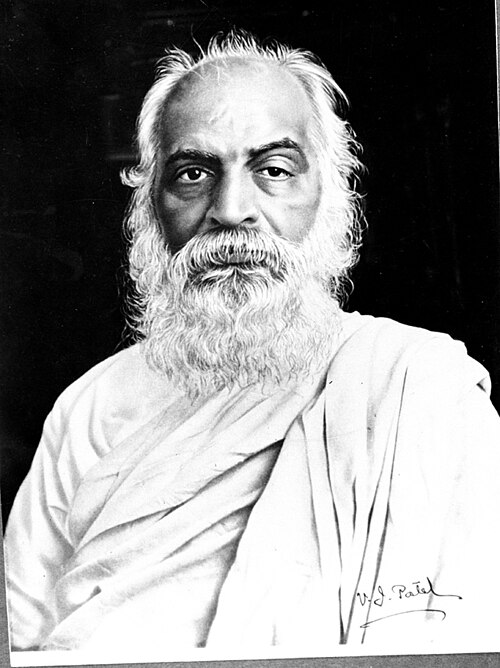 A black-and-white studio portrait of Vithalbhai Patel, white-bearded and wearing a white shawl, with his signature in the corner