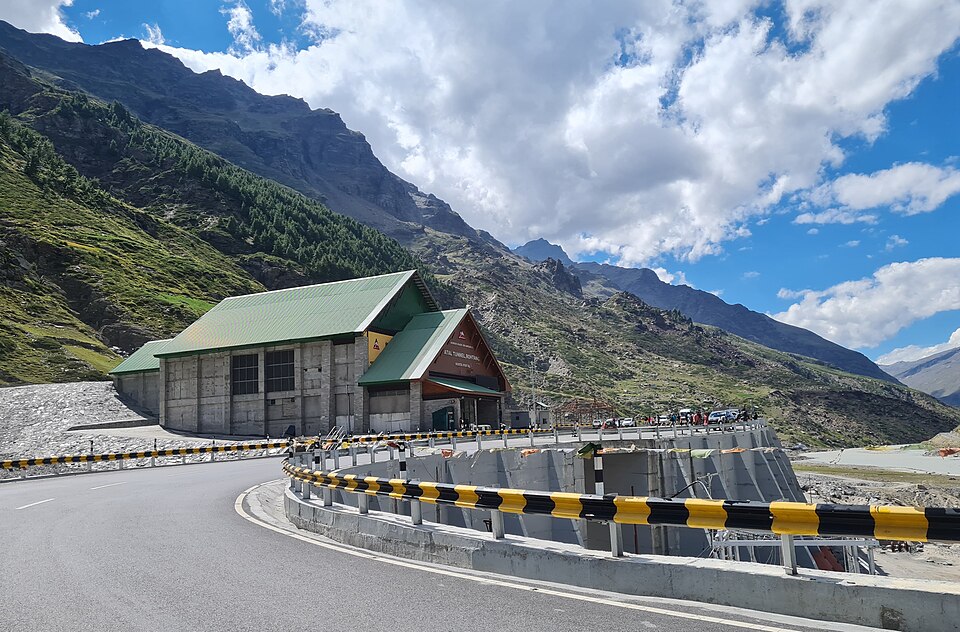 The portal building of the Atal Tunnel at Rohtang with the approach road curving towards it between Himalayan slopes