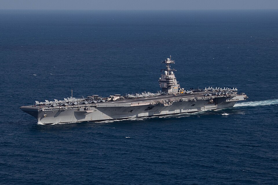 The aircraft carrier USS Gerald R. Ford under way at sea, seen from the air with aircraft parked on its flight deck