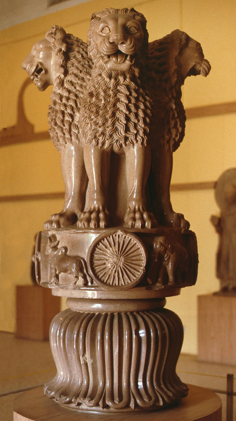 The Lion Capital of Ashoka from Sarnath: four addorsed lions standing on a round abacus carved with a bull, a spoked wheel and an elephant, above an inverted lotus base
