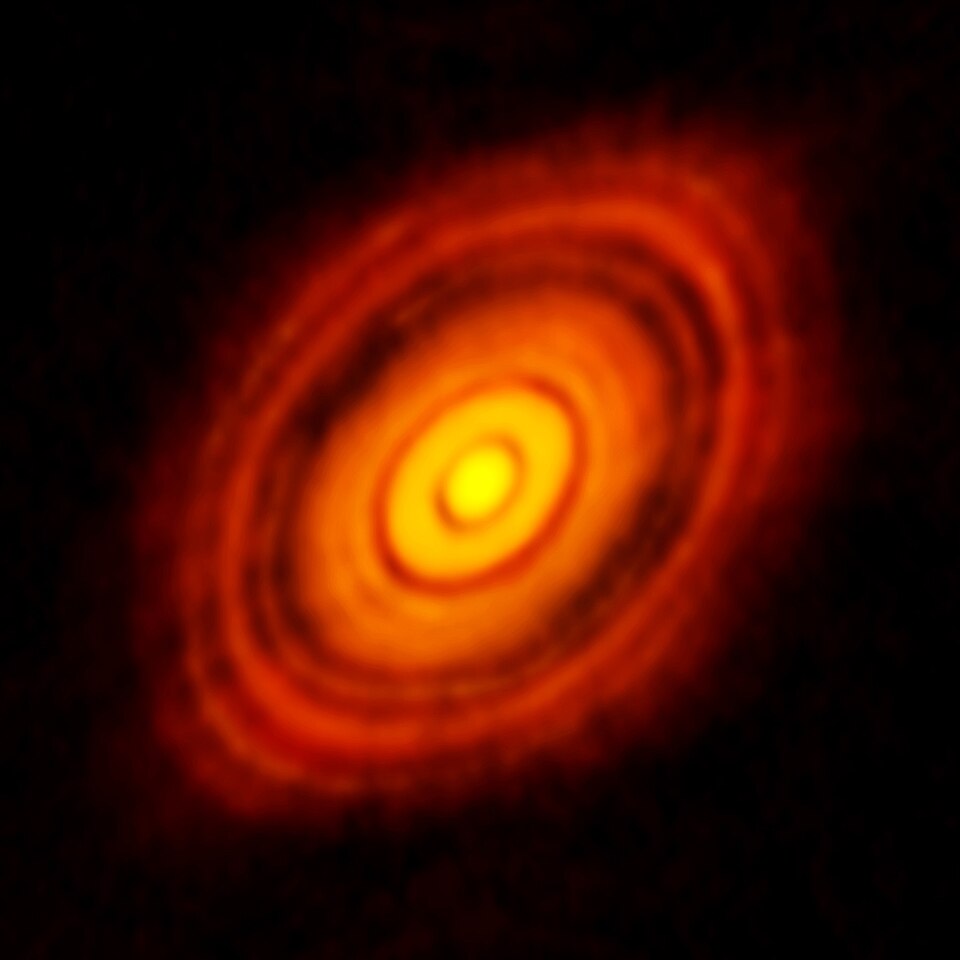 A radio image of the young star HL Tauri: a bright core surrounded by a tilted orange disc of dust cut by concentric dark gaps