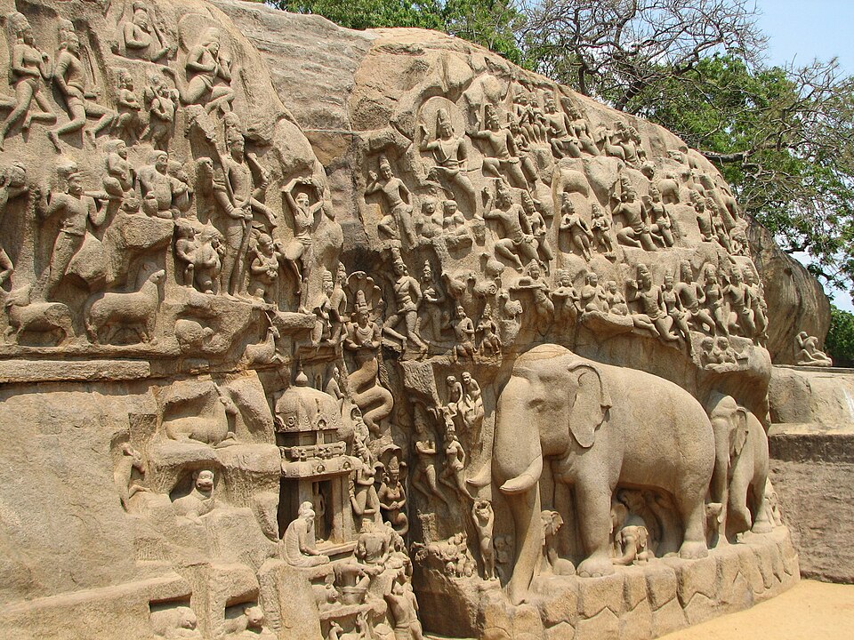 The giant rock-cut relief at Mamallapuram known as Arjuna's Penance, with rows of celestial figures, ascetics and animals carved across the granite face and a life-size elephant at the lower right