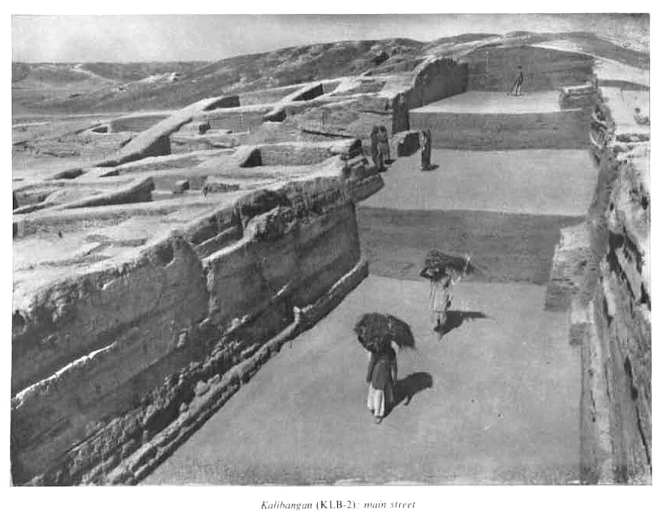 Archaeological Survey of India photograph of the excavated main street at Kalibangan, running between exposed mud-brick house walls cut into the mound