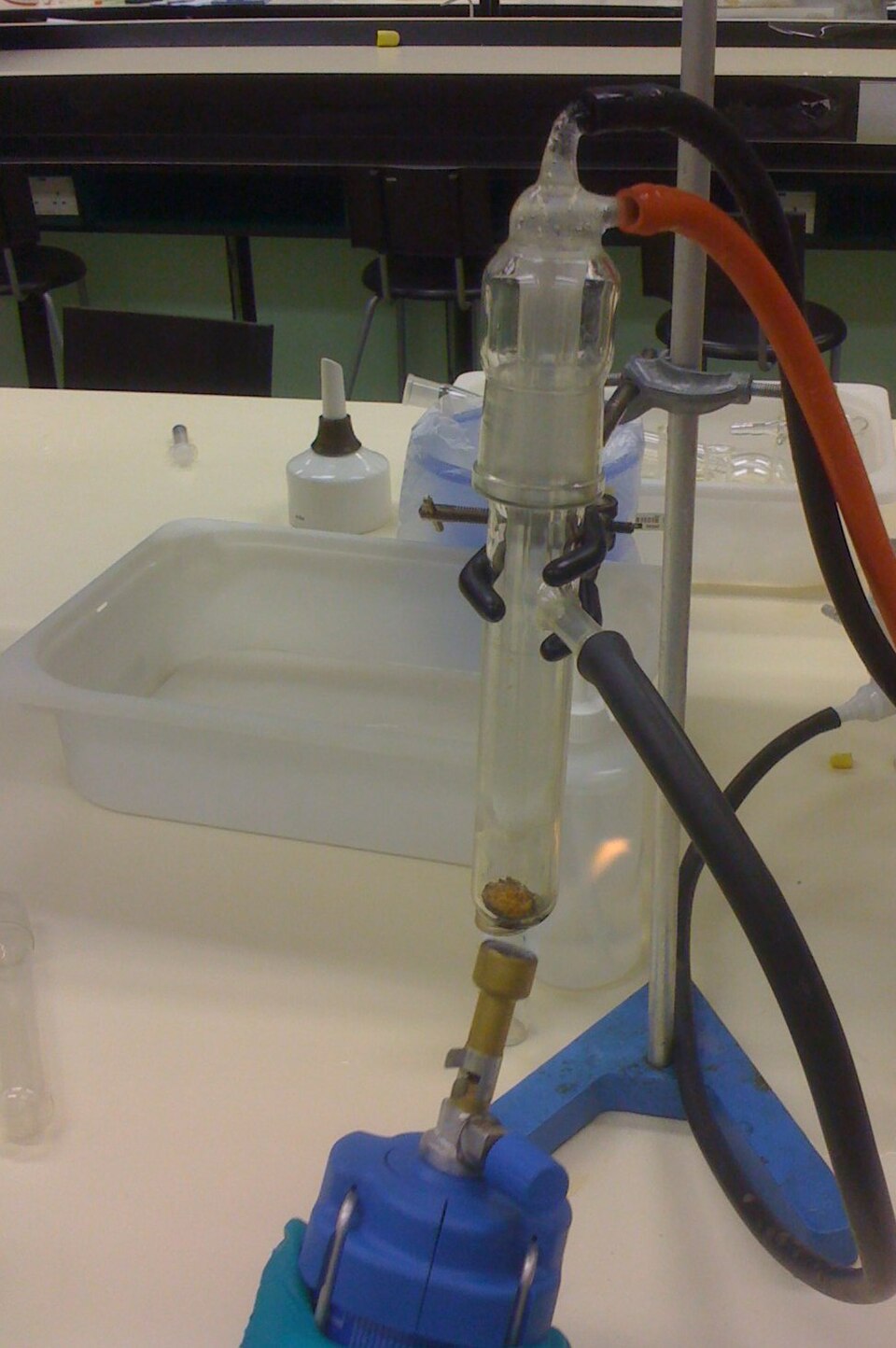 Camphor being sublimed in a laboratory tube heated by a burner, the vapour re-crystallising as white solid on the cold finger above without ever becoming liquid.