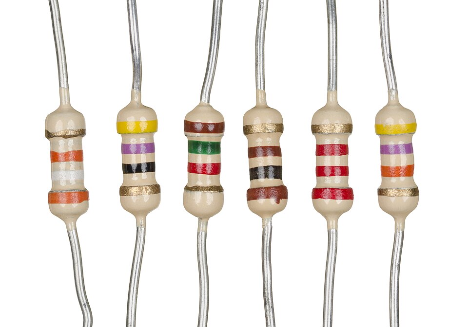 Six axial-lead electronic resistors with coloured value bands, shown side by side against a white background.