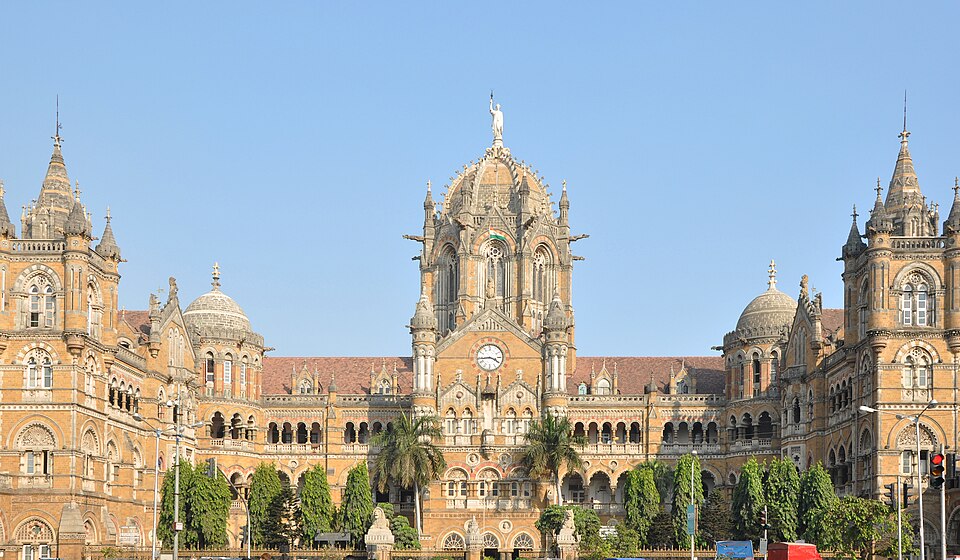 The Gothic Revival facade of Chhatrapati Shivaji Maharaj Terminus in Mumbai, with its central dome, clock and turrets under a clear sky.