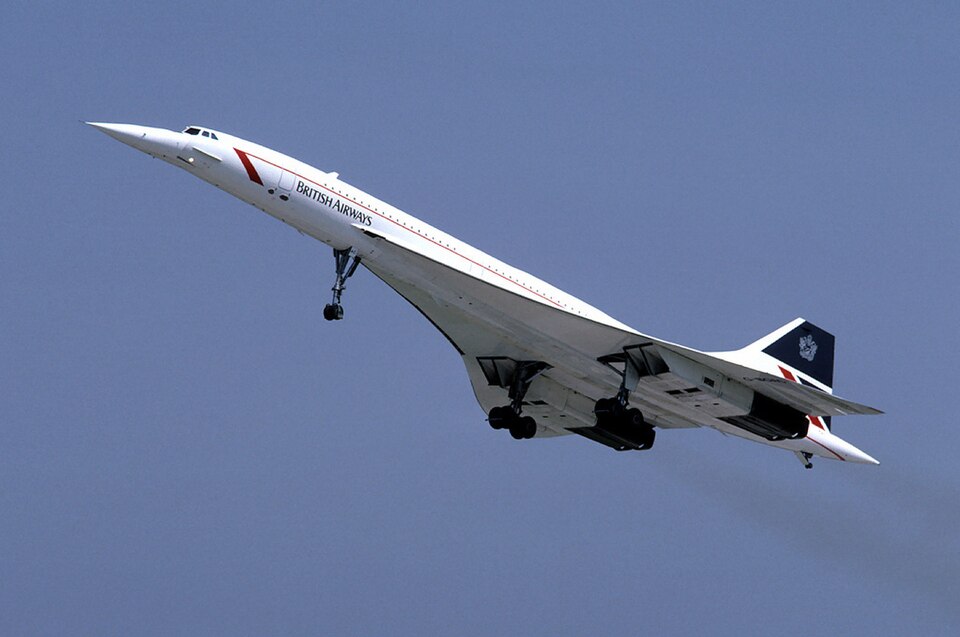 A British Airways Concorde climbing after take-off against a clear sky, showing its slender delta wing and drooped needle nose.