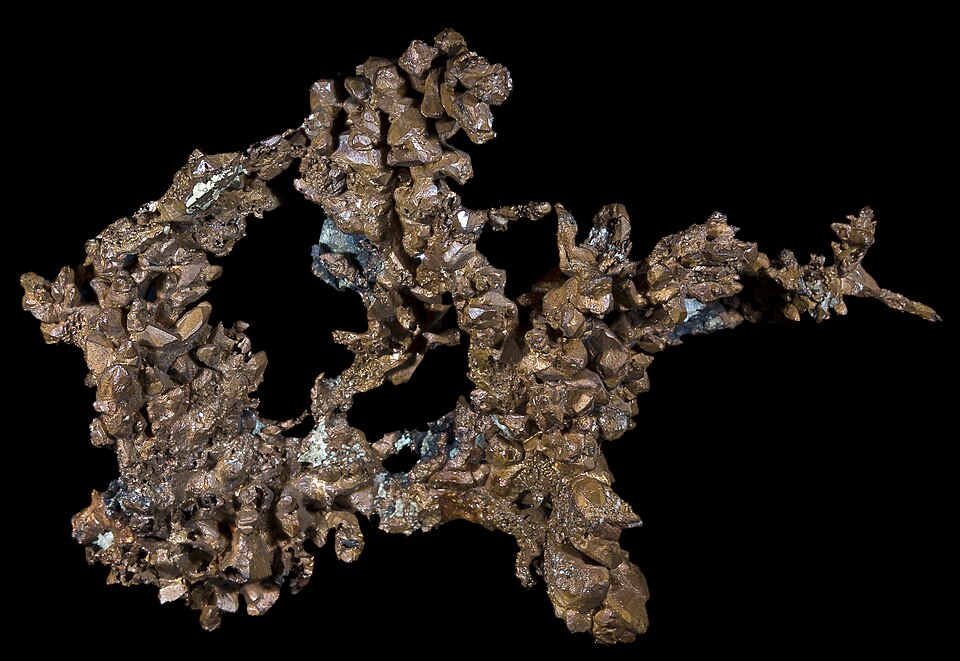 A specimen of native copper, a branching metallic mass of coppery crystals, photographed against a black background.