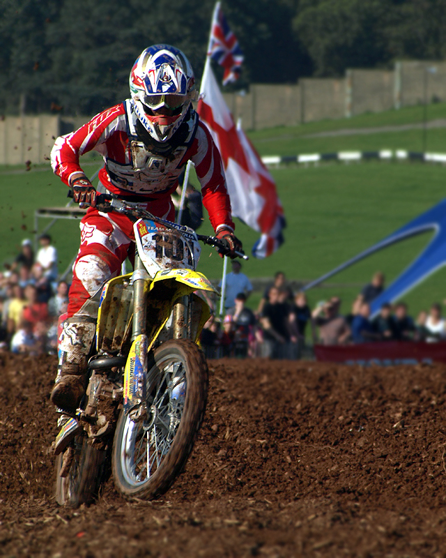 An off-road motocross racer in action on a dirt circuit.