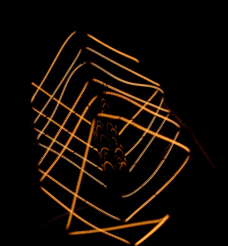 Close-up of the glowing coiled tungsten filament of an incandescent light bulb
