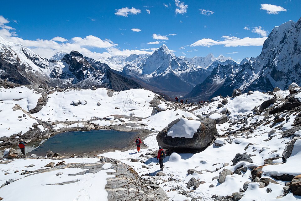 High snow-capped Himalayan peaks above a glacial valley and tarn in the Nepal Himalaya