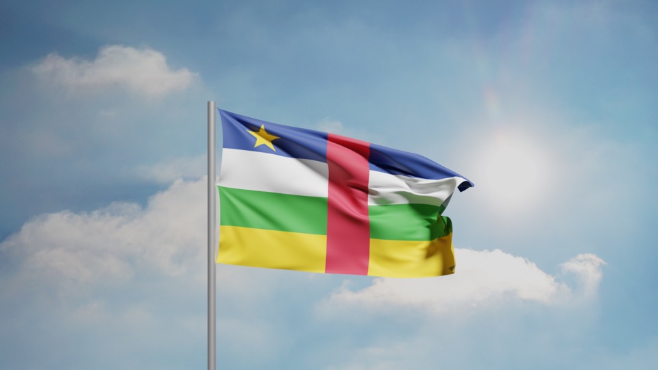The national flag of the Central African Republic waving against a blue sky