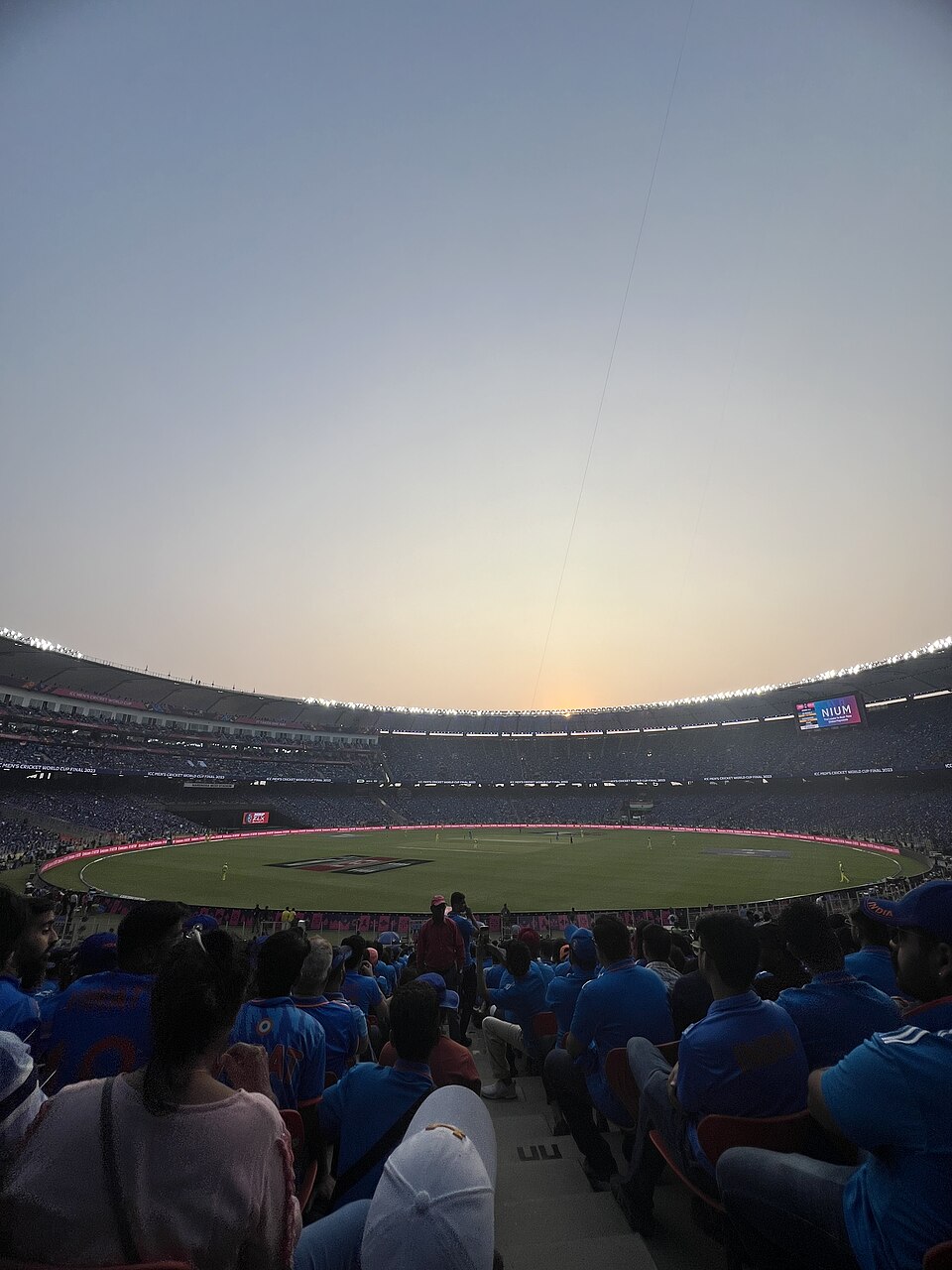 The vast bowl of the Narendra Modi Stadium in Ahmedabad packed with spectators around the cricket field at dusk