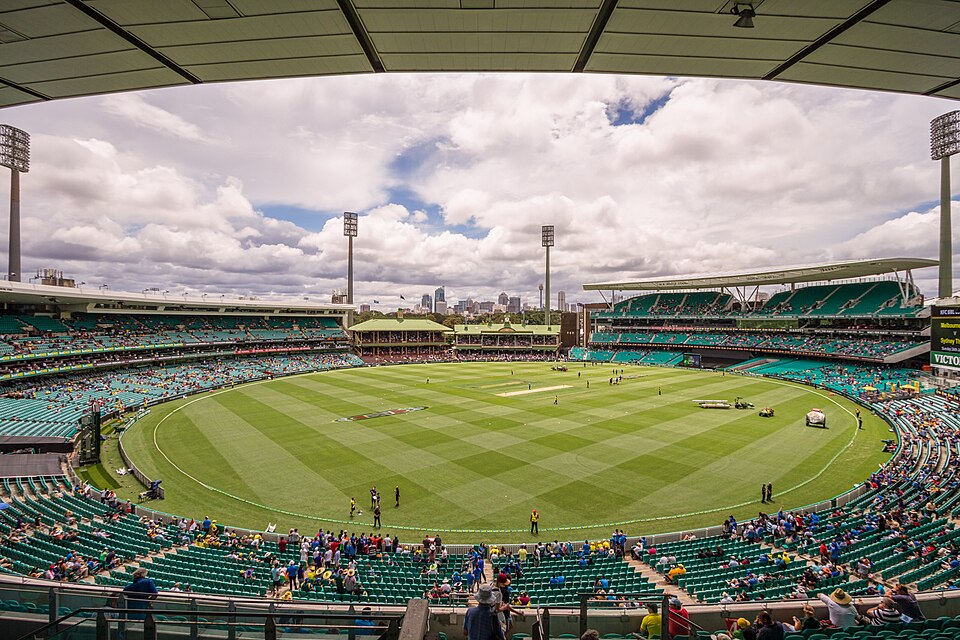 Interior of the Sydney Cricket Ground with its striped oval, grandstands and heritage pavilion under a cloudy sky