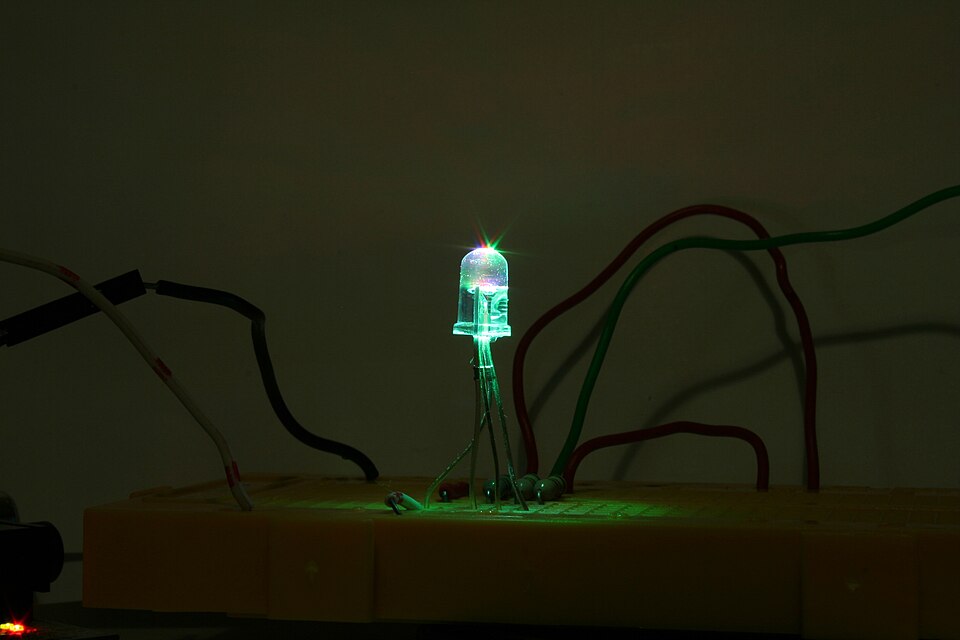 A light-emitting diode (LED) glowing on a breadboard