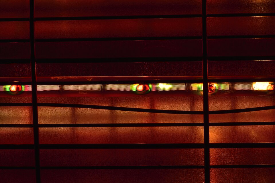 Red-hot glowing resistive heating element of an electric heater seen through its protective grille