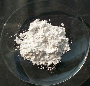 White plaster of Paris (calcium sulfate hemihydrate) powder in a watch glass