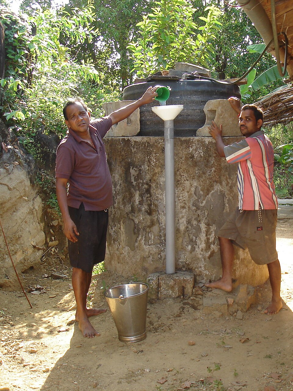 A domed rural household biogas (gobar gas) plant being fed dung slurry in an Indian village