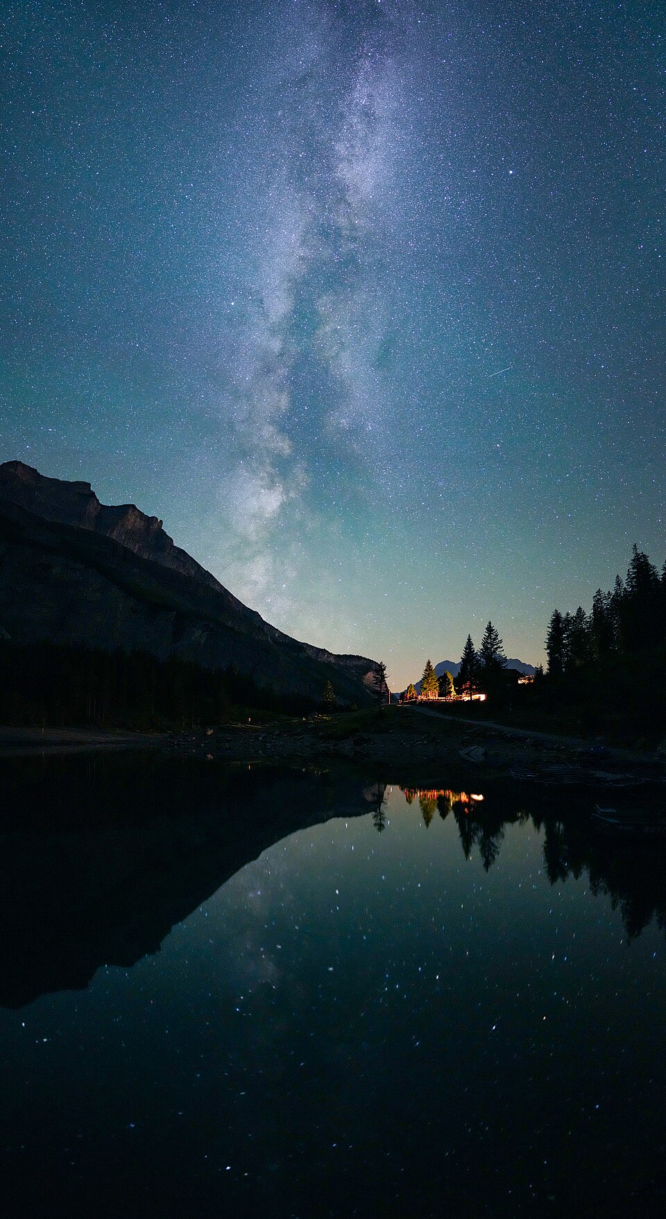 A clear night sky filled with stars and the Milky Way over a mountain lake