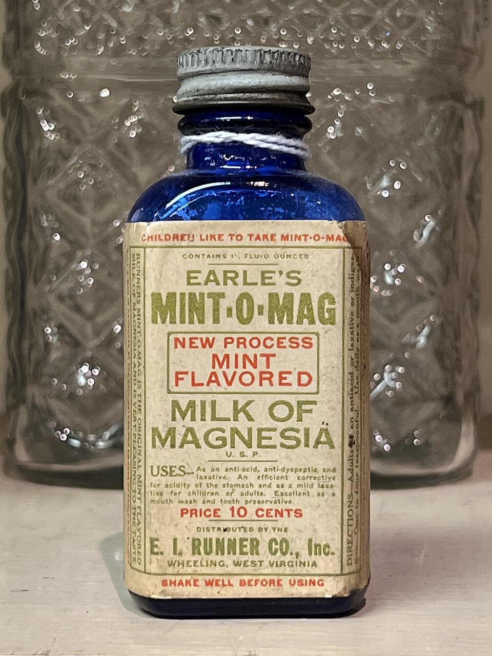 A small bottle labelled Milk of Magnesia, the magnesium hydroxide antacid suspension.