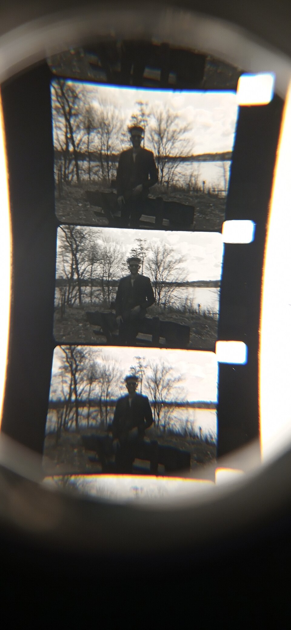 A strip of black-and-white photographic film negatives held up and viewed against the light.