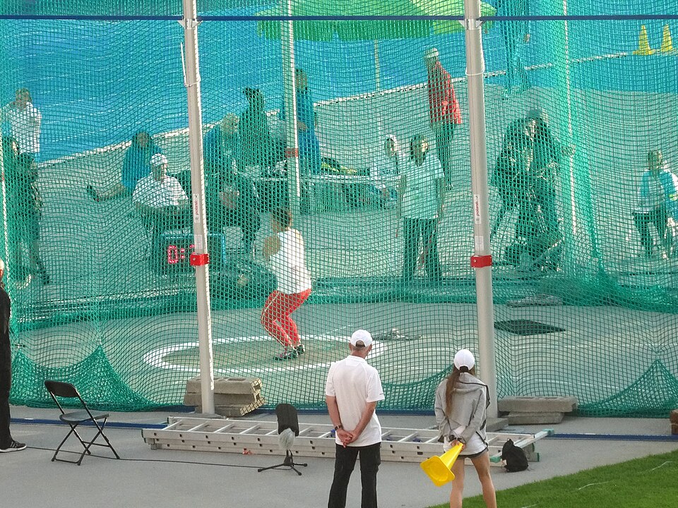 An athlete whirling the hammer in a circle inside a throwing cage, illustrating uniform circular motion.