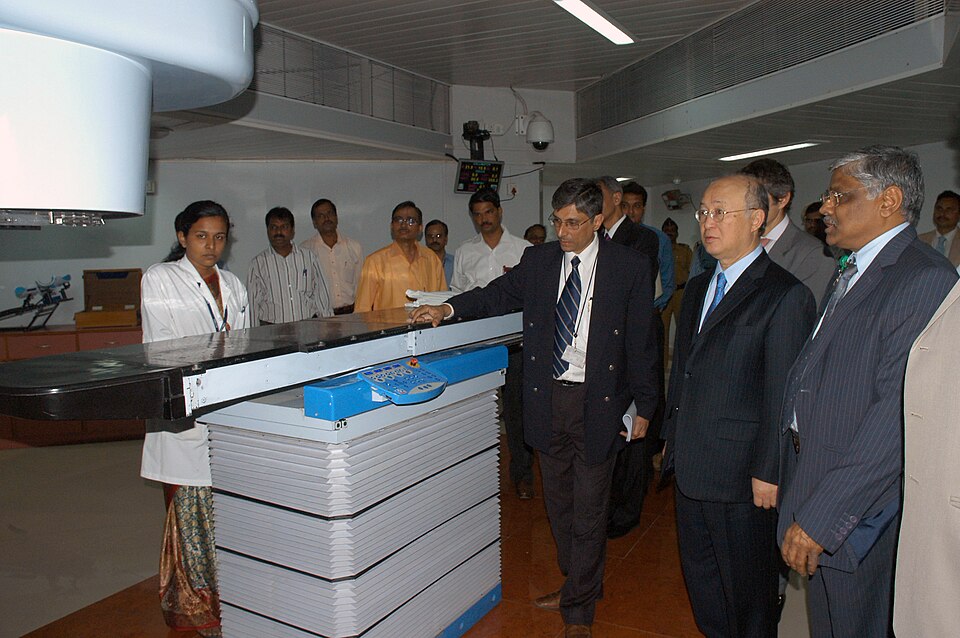A Cobalt-60 teletherapy (Bhabhatron) radiotherapy machine with treatment couch in a hospital room.