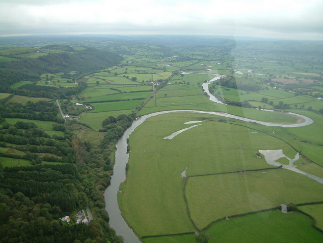 Aerial view of a meandering river with a looping bend and cut-off oxbow lake on a floodplain