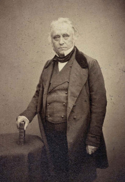 Studio portrait photograph of Thomas Babington Macaulay, Lord Macaulay, standing with a book