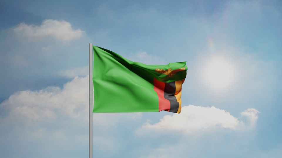 The national flag of Zambia: a green field with an orange eagle above red-black-orange vertical stripes at the fly.