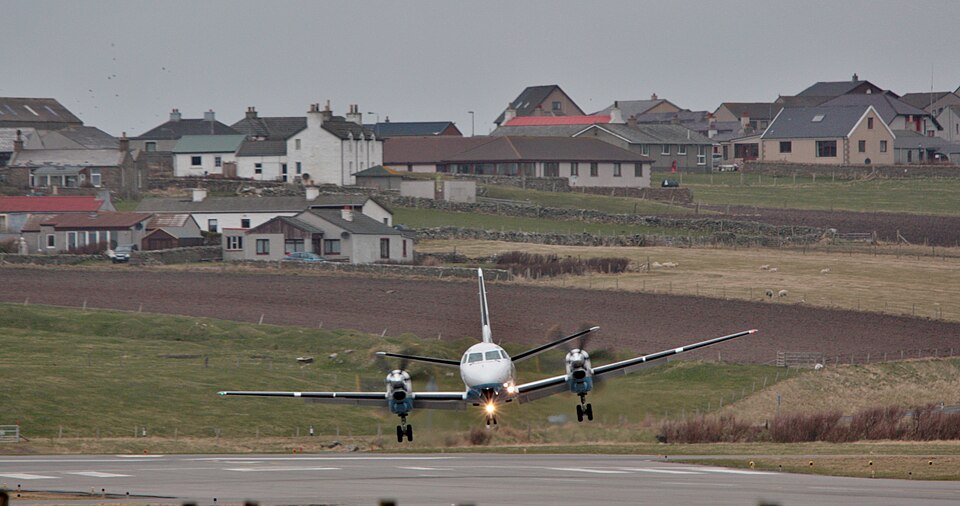 A passenger aircraft with landing gear down touching down on the runway