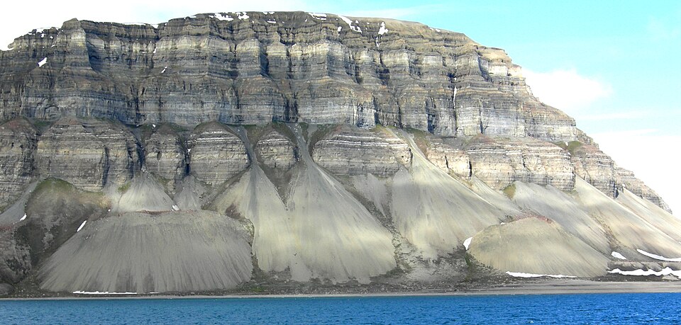 Talus cones of rock debris at the base of a steep cliff, an example of mass wasting