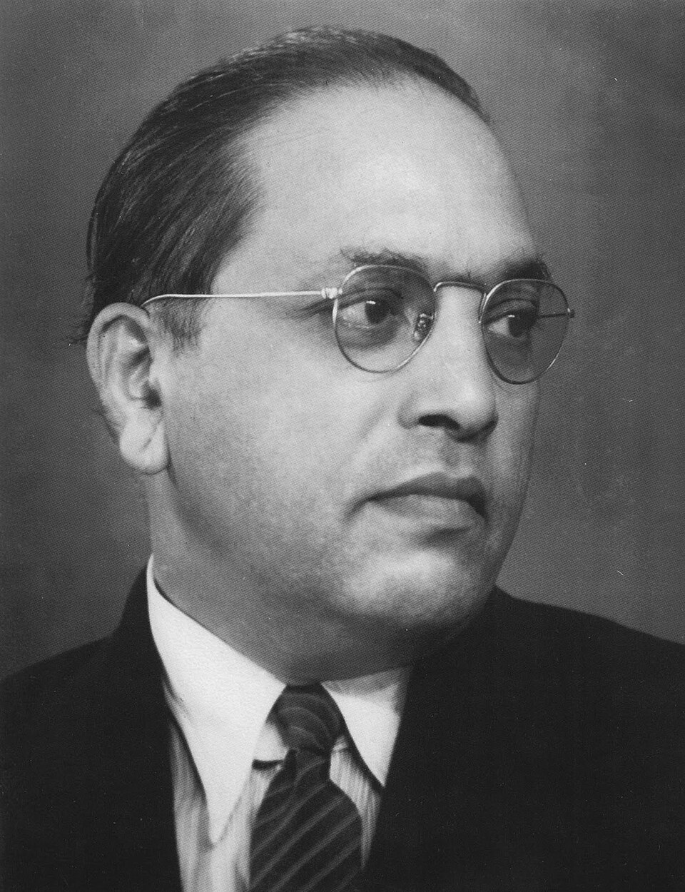 Portrait of Dr B. R. Ambedkar wearing round spectacles and a suit
