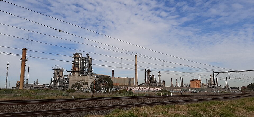 A petroleum refinery showing tall fractionating distillation columns and chimneys