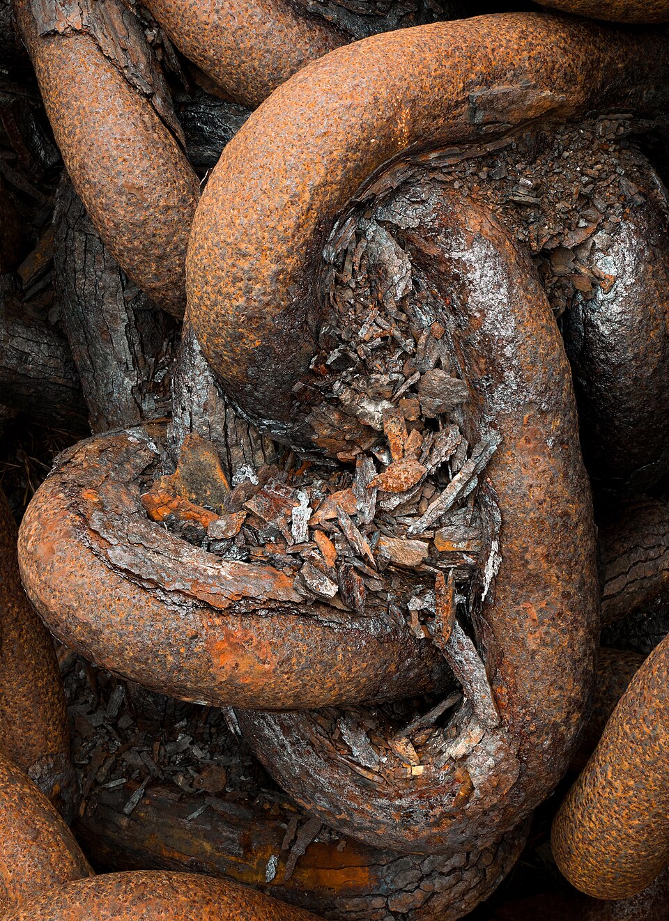 Heavily rusted reddish-brown corroded iron chain links