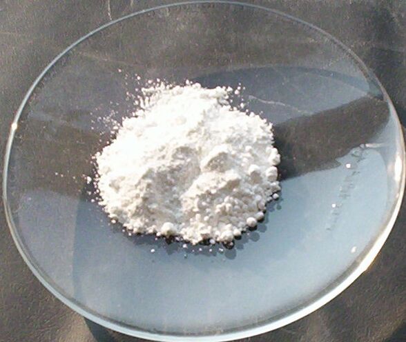 A heap of fine white zinc oxide pigment powder in a watch glass
