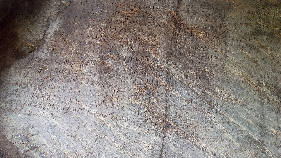 Close view of the Ashokan rock edict at Dhauli near Bhubaneswar, Odisha, with lines of Brahmi characters cut into the weathered rock face.