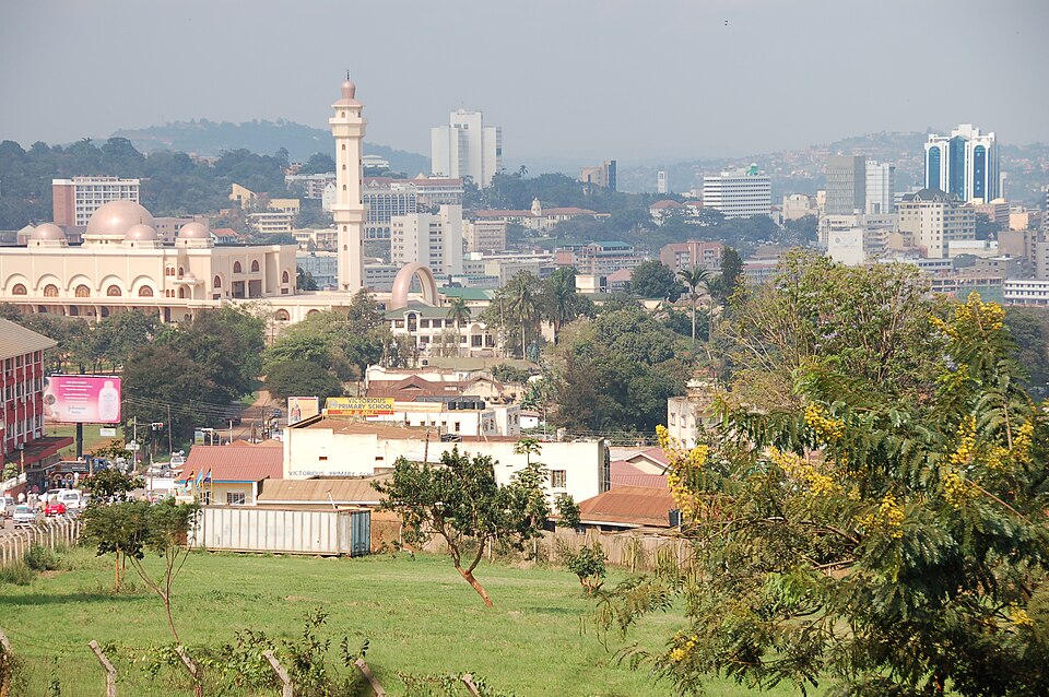 View across Kampala, the capital of Uganda, with the domed national mosque and its minaret in the foreground and the city's high-rise centre on the hills behind.