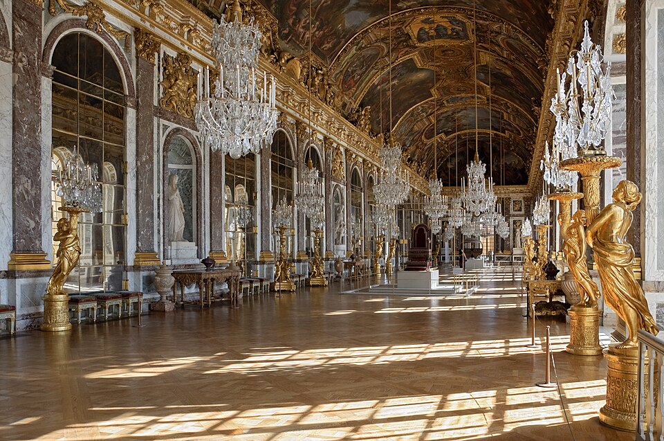 The Hall of Mirrors at the Palace of Versailles, a long gilded gallery lined with mirrored arches, crystal chandeliers and gilt statues under a painted barrel vault.