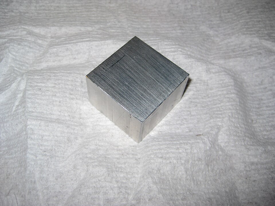 A shiny silvery block of aluminium metal with a machined surface