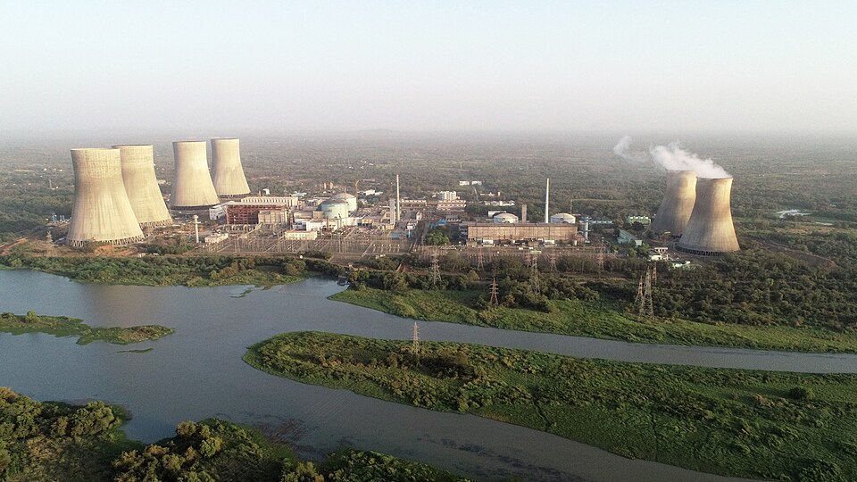 Aerial view of Kakrapar Atomic Power Station, Gujarat, with cooling towers and reactor domes beside a river