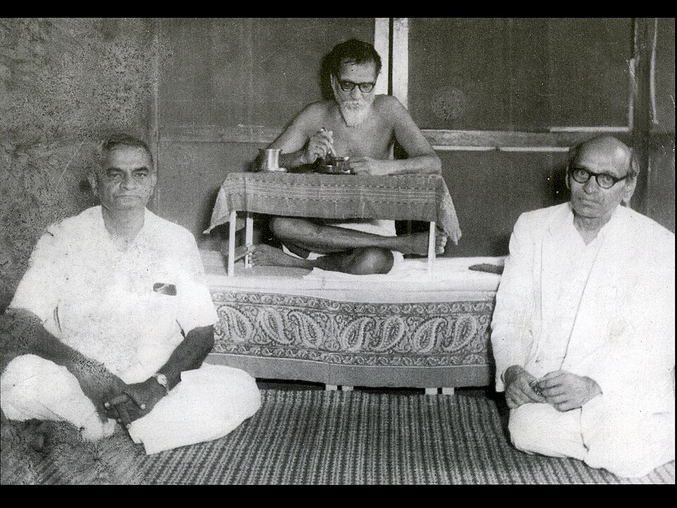 Acharya Vinoba Bhave, the central bare-torsoed ascetic figure with glasses, seated cross-legged with two visitors
