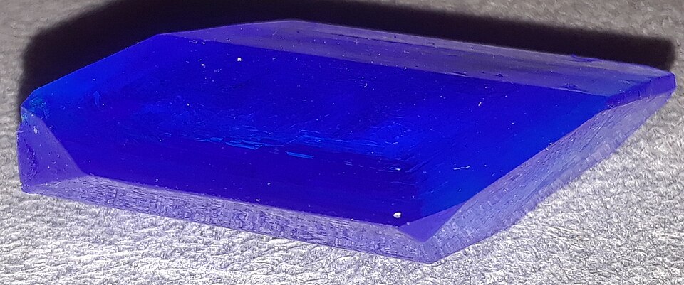 A single deep-blue crystal of copper sulphate (blue vitriol), a pure chemical compound