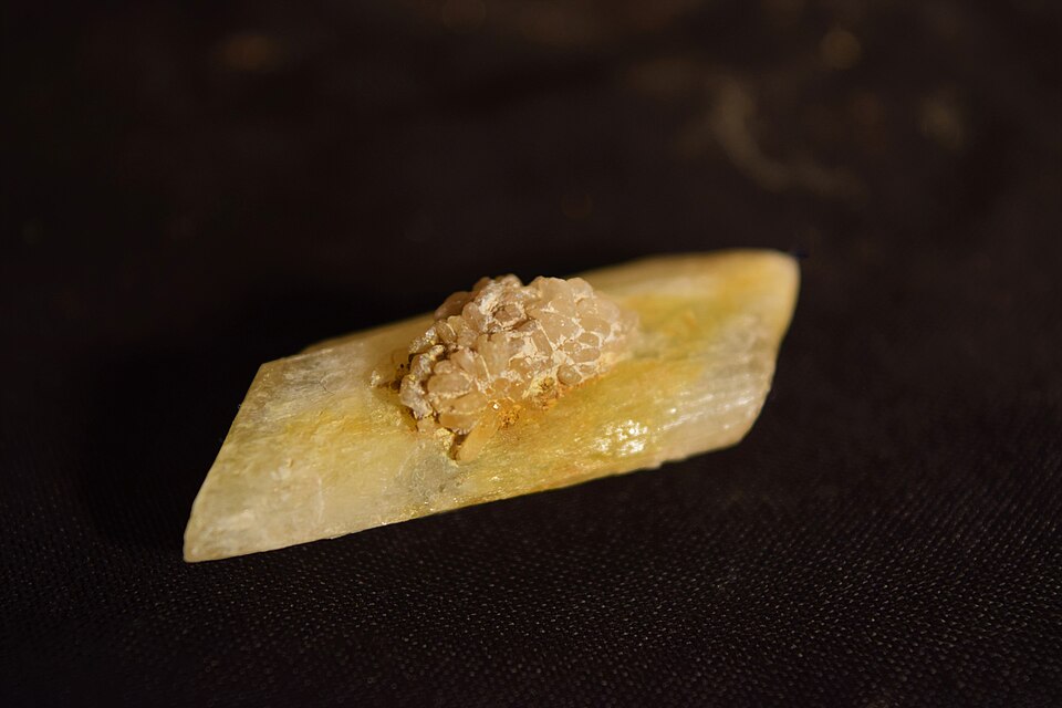 A translucent gypsum selenite crystal (hydrated calcium sulphate) with a rosette cluster on its surface