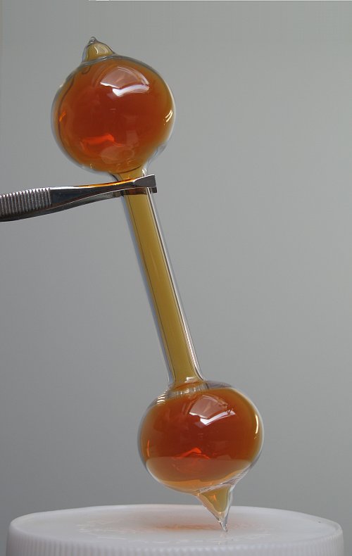 Brown nitrogen dioxide gas sealed inside a dumbbell-shaped glass ampoule