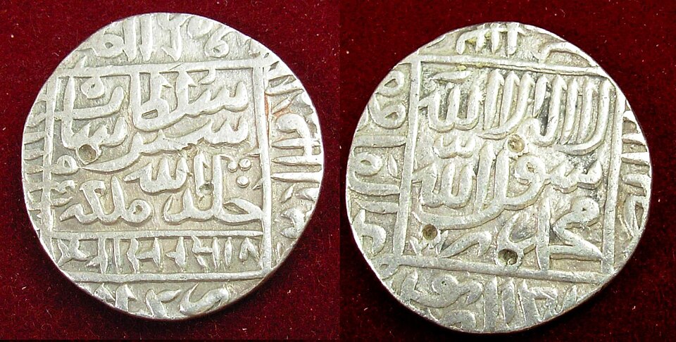 Obverse and reverse of a silver rupiya of Sher Shah Suri laid on dark red cloth, each face carrying an Arabic inscription inside a square frame with a marginal legend, and Devanagari lettering along the lower edge